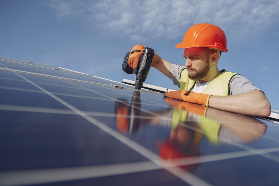 Friendly and professional solar panel installer reviewing project plans with a homeowner